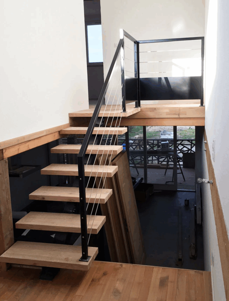 Escalier suspendu acier et marches en bois avec garde‑corps à câbles, intérieur moderne