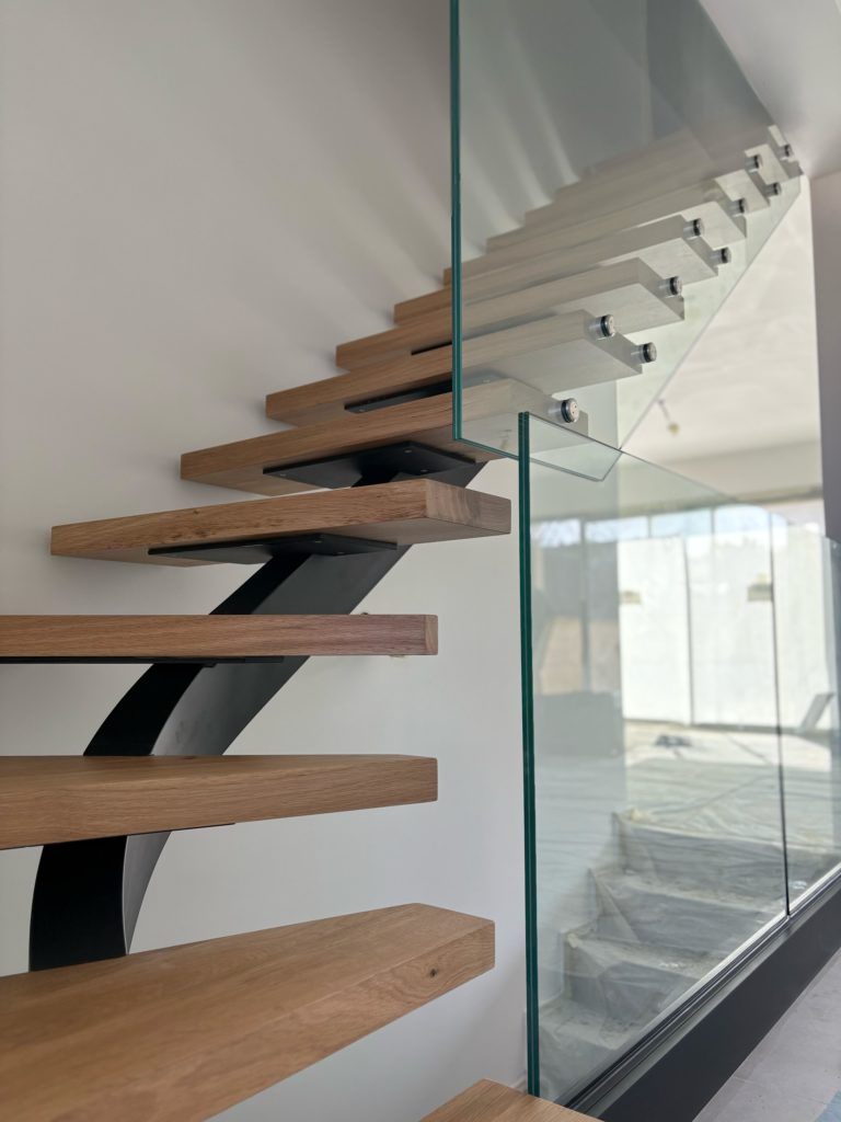 Escalier sur mesure en acier et bois, marches flottantes avec garde-corps en verre, design moderne intérieur lumineux
